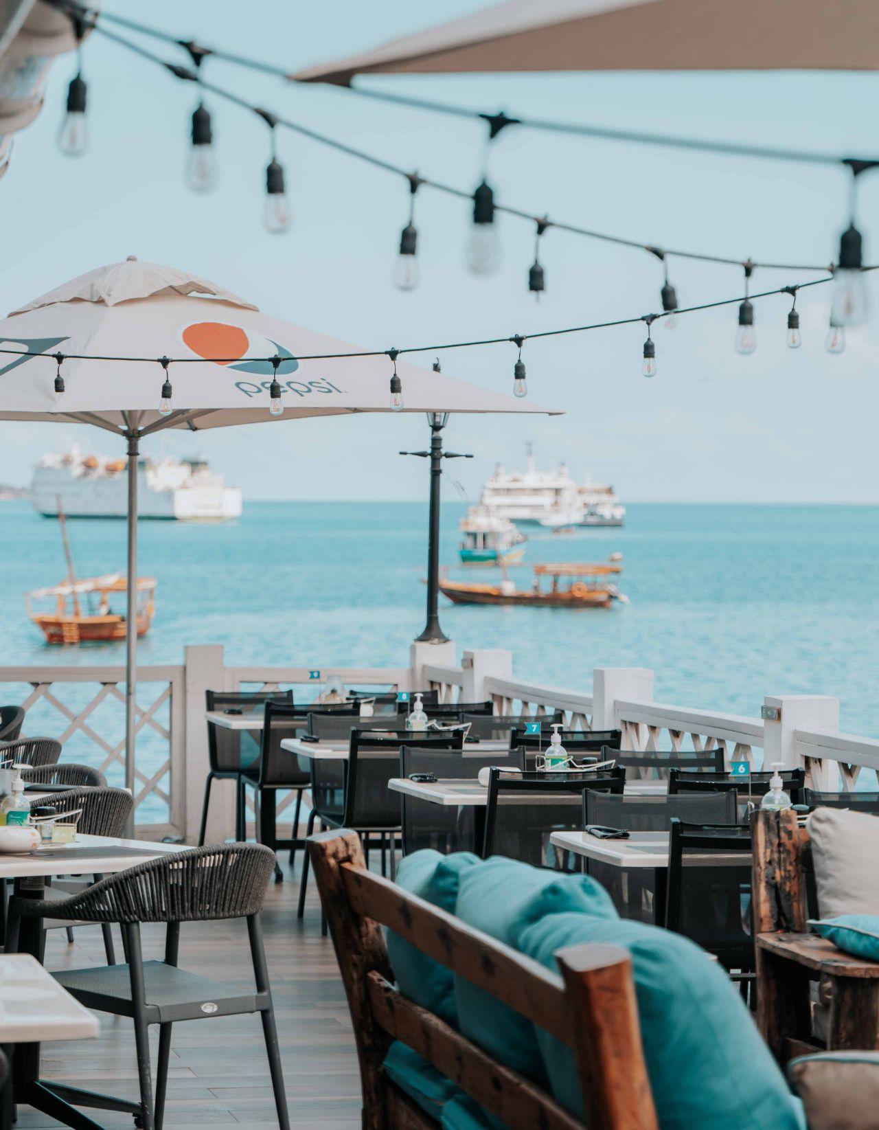 Terraza del restaurante frente al mar con luces colgantes