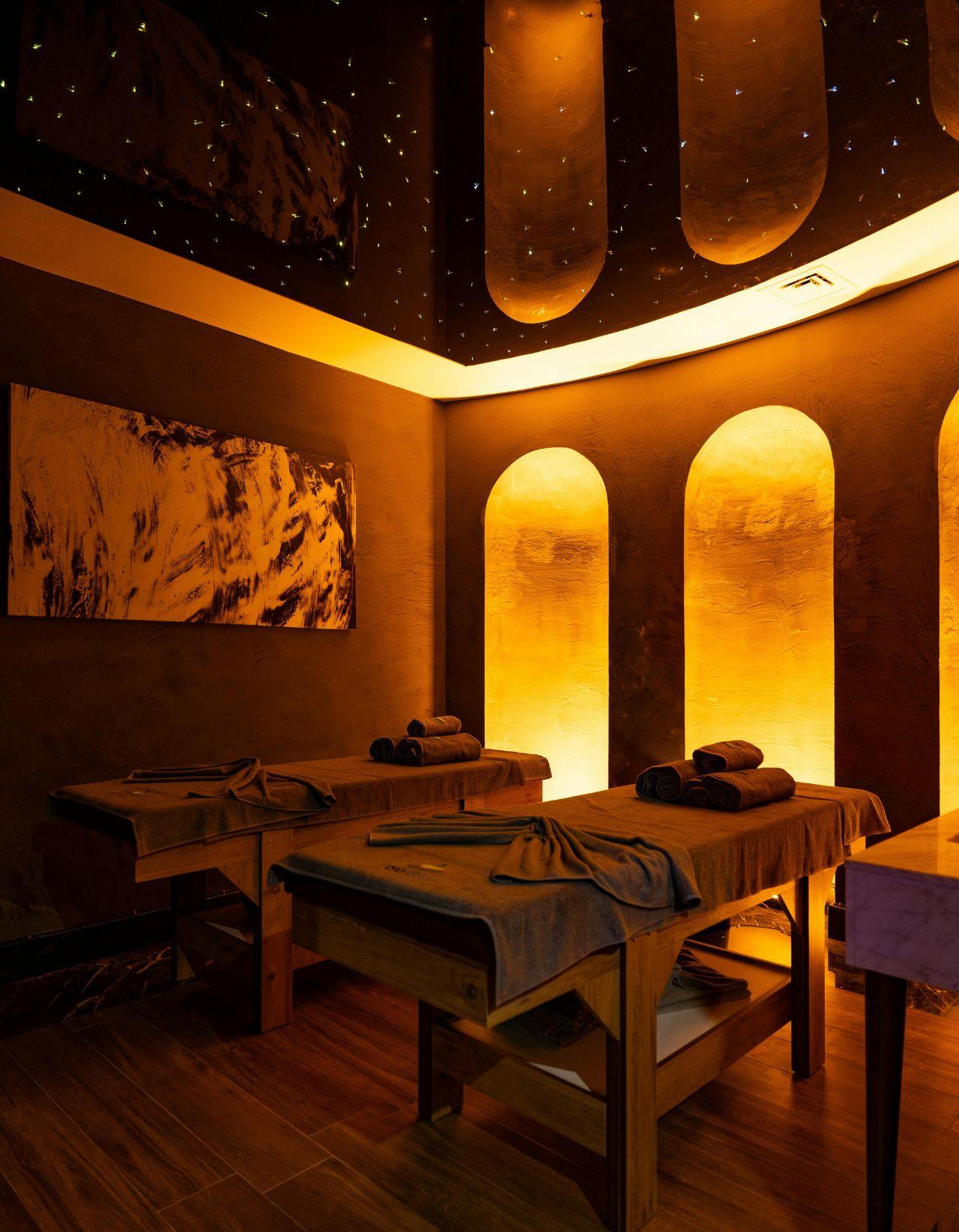 Cabina de masajes con dos camillas y nichos iluminados